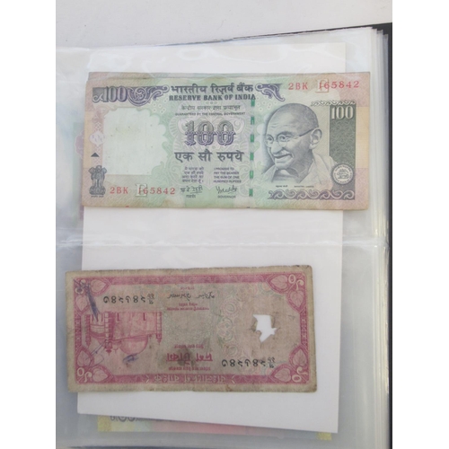 223 - Two folders containing International banknotes from India, Japan, Republic of China, Myanmar, Cambod... 