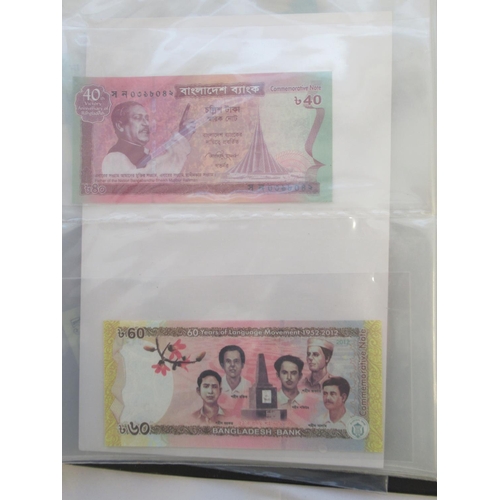 223 - Two folders containing International banknotes from India, Japan, Republic of China, Myanmar, Cambod... 