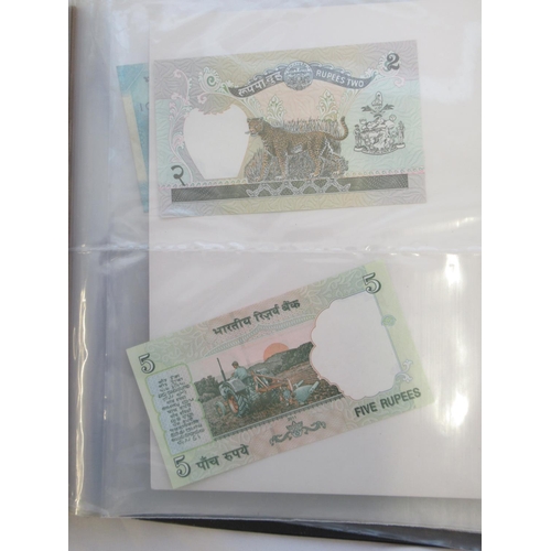 223 - Two folders containing International banknotes from India, Japan, Republic of China, Myanmar, Cambod... 