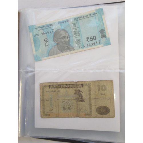 223 - Two folders containing International banknotes from India, Japan, Republic of China, Myanmar, Cambod... 