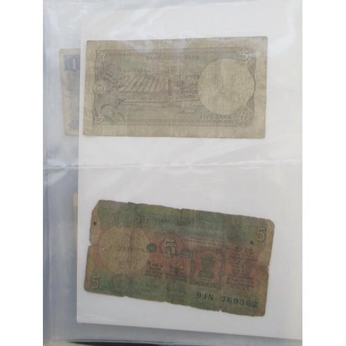 223 - Two folders containing International banknotes from India, Japan, Republic of China, Myanmar, Cambod... 