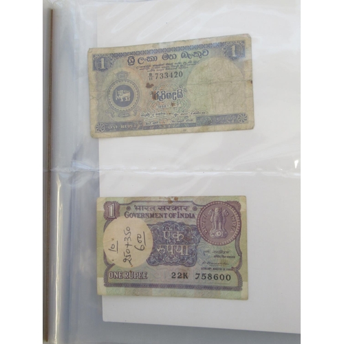 223 - Two folders containing International banknotes from India, Japan, Republic of China, Myanmar, Cambod... 