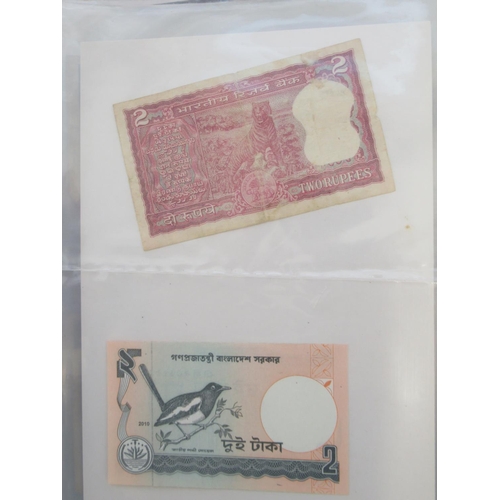 223 - Two folders containing International banknotes from India, Japan, Republic of China, Myanmar, Cambod... 