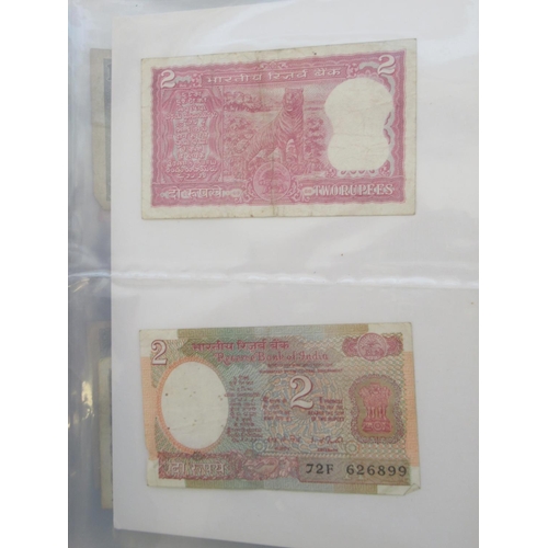 223 - Two folders containing International banknotes from India, Japan, Republic of China, Myanmar, Cambod... 