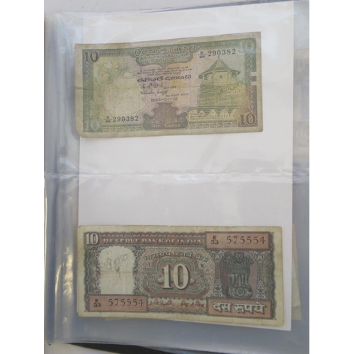 223 - Two folders containing International banknotes from India, Japan, Republic of China, Myanmar, Cambod... 