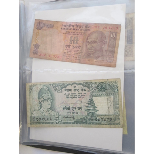 223 - Two folders containing International banknotes from India, Japan, Republic of China, Myanmar, Cambod... 