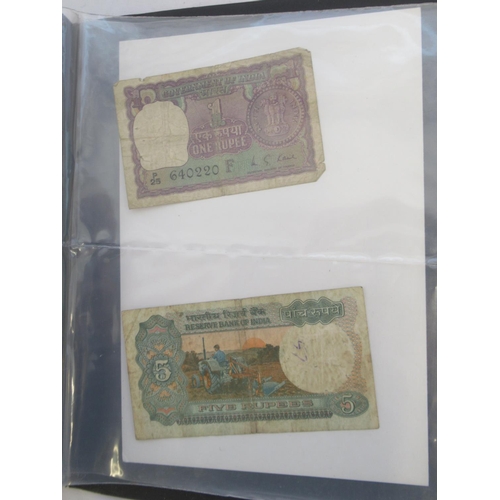 223 - Two folders containing International banknotes from India, Japan, Republic of China, Myanmar, Cambod... 