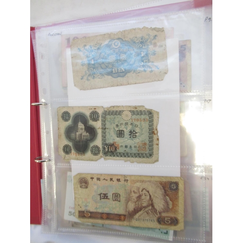 223 - Two folders containing International banknotes from India, Japan, Republic of China, Myanmar, Cambod... 