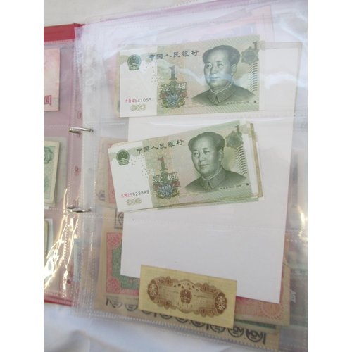 223 - Two folders containing International banknotes from India, Japan, Republic of China, Myanmar, Cambod... 