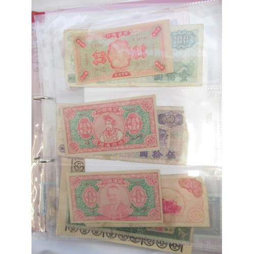 223 - Two folders containing International banknotes from India, Japan, Republic of China, Myanmar, Cambod... 