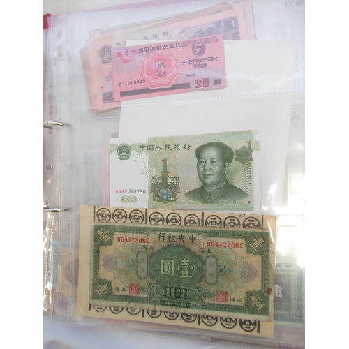 223 - Two folders containing International banknotes from India, Japan, Republic of China, Myanmar, Cambod... 