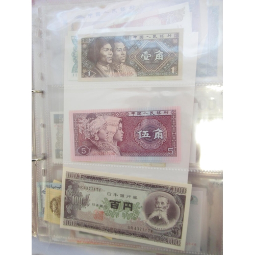 223 - Two folders containing International banknotes from India, Japan, Republic of China, Myanmar, Cambod... 