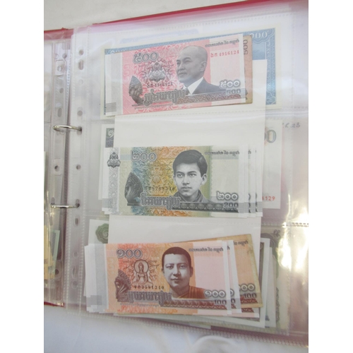 223 - Two folders containing International banknotes from India, Japan, Republic of China, Myanmar, Cambod... 