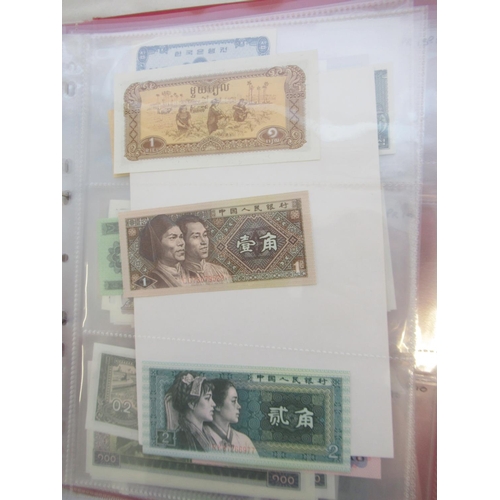 223 - Two folders containing International banknotes from India, Japan, Republic of China, Myanmar, Cambod... 