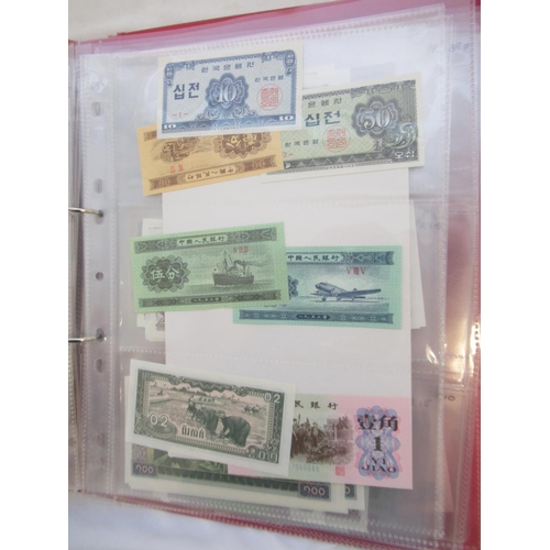 223 - Two folders containing International banknotes from India, Japan, Republic of China, Myanmar, Cambod... 