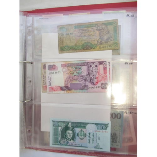 223 - Two folders containing International banknotes from India, Japan, Republic of China, Myanmar, Cambod... 