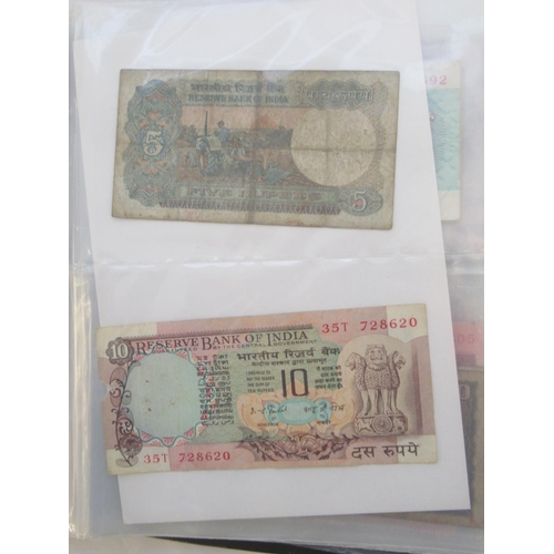 223 - Two folders containing International banknotes from India, Japan, Republic of China, Myanmar, Cambod... 