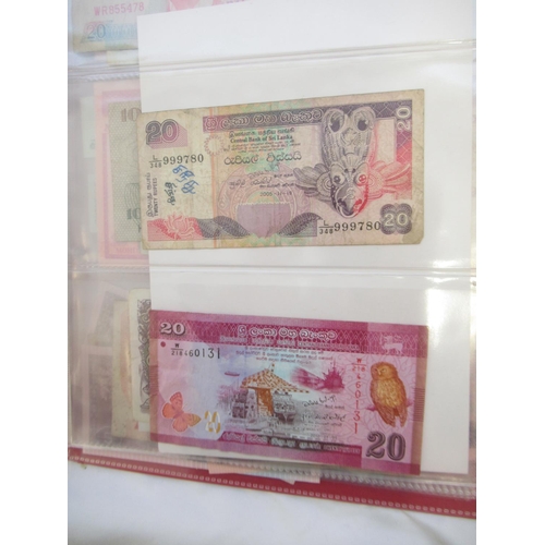 223 - Two folders containing International banknotes from India, Japan, Republic of China, Myanmar, Cambod... 