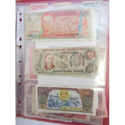 223 - Two folders containing International banknotes from India, Japan, Republic of China, Myanmar, Cambod... 