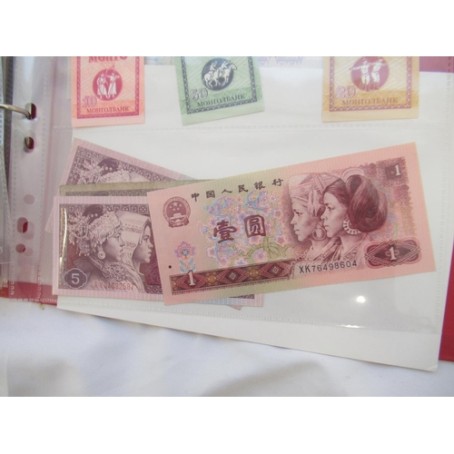 223 - Two folders containing International banknotes from India, Japan, Republic of China, Myanmar, Cambod... 