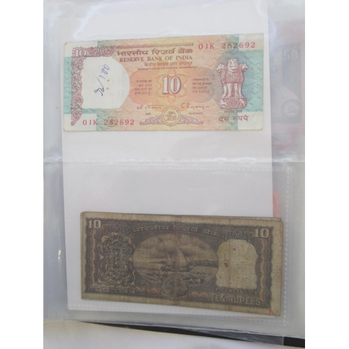 223 - Two folders containing International banknotes from India, Japan, Republic of China, Myanmar, Cambod... 