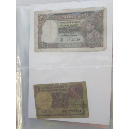 223 - Two folders containing International banknotes from India, Japan, Republic of China, Myanmar, Cambod... 