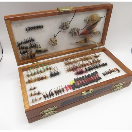 447 - Collection of fly fishing flies of various sizes and styles, immaculately presented in a wooden Shak... 