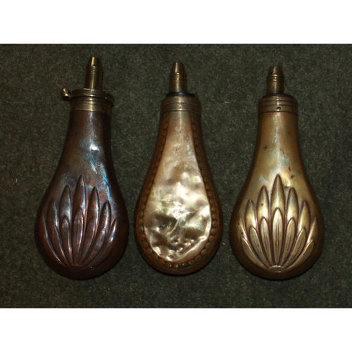 423 - Two copper and brass powder flasks with fluted leaf design and a 'rivet' style flask. All by Sykes.