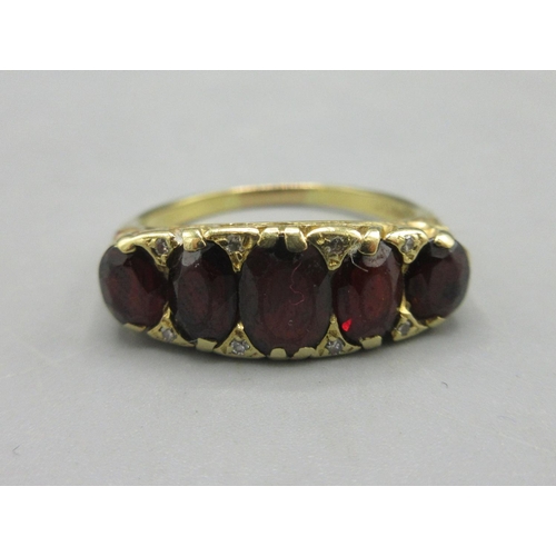 24 - 18ct yellow gold ring set with five red stones in ornate mount, stamped 18, size R1/2, 5.58g