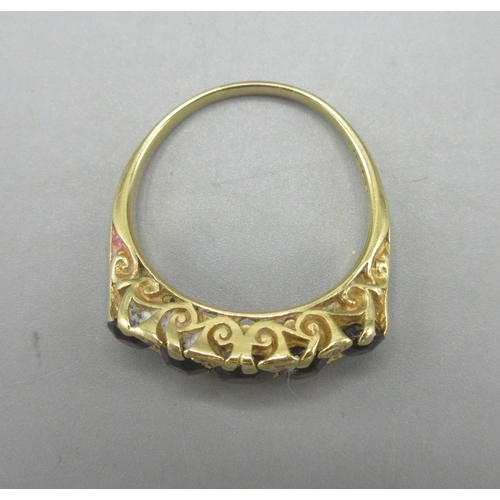 24 - 18ct yellow gold ring set with five red stones in ornate mount, stamped 18, size R1/2, 5.58g