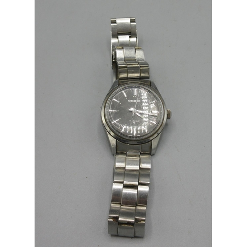 525 - Seiko stainless steel wristwatch on matching bracelet with signed clasp, signed sunburst charcoal gr... 