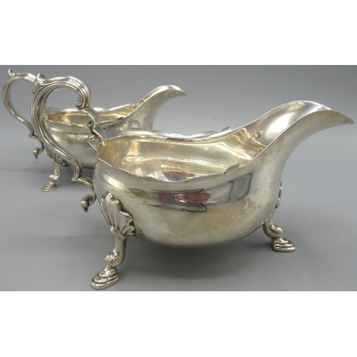 1036 - Pair of George V silver sauce boats with flared pie crust rims, stood on three shell cast hoof feet,... 