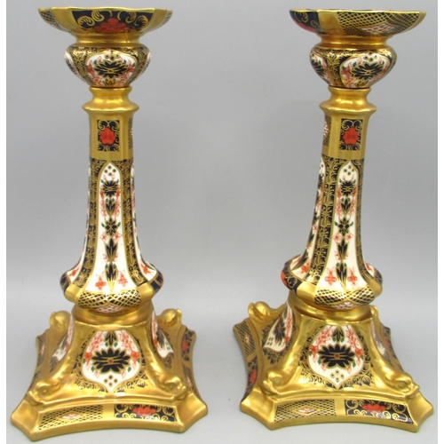 Pair of Royal Crown Derby Imari candlesticks, pattern 1128, shaped circular sconces and tapered columns on dolphin moulded shaped square bases, printed and painted marks, date code for 1938, H27cm (2)