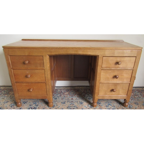 1364 - Robert Mouseman Thompson of Kilburn - an oak panelled kneehole desk or dressing table, adzed top abo...