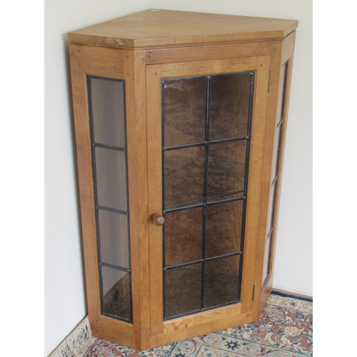 Robert Mouseman Thompson of Kilburn - an oak corner cabinet, with lead glazed side panels and door, carved with signature mouse, W69cm D46cm H97cm