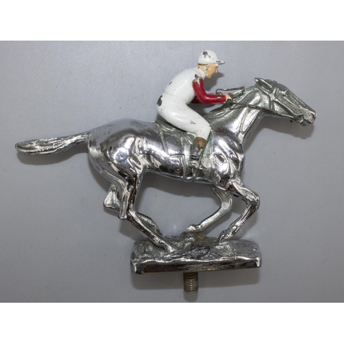 1132 - Chromed metal car bonnet mascot, modelled as a galloping racehorse with jockey in enamelled silks up... 