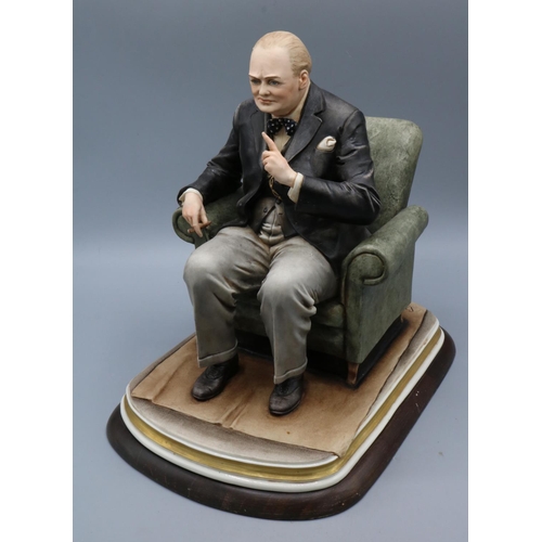 1169 - Capo-di-Monte porcelain figure of Winston Churchill seated in an armchair with cigar in hand, modell... 