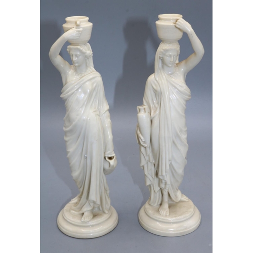 1219 - Pair of Royal Worcester models of female Grecian water carriers on circular bases, one with puce pri... 