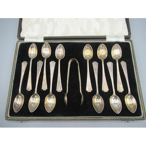 108 - C20th silver cased set of twelve teaspoons with sugar tongs, in an Art Deco style, triangular engine... 