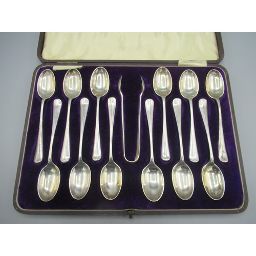 109 - George V silver cased set of twelve monogrammed teaspoons with sugar tongs, hanover finials and rat ... 