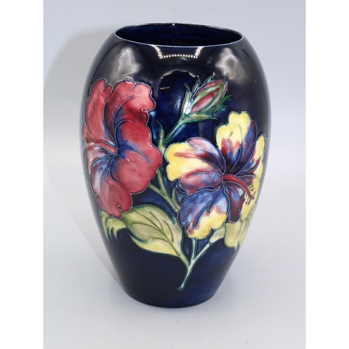 721 - Moorcroft Pottery, Hibiscus pattern ovoid vase, red and yellow flowers on dark blue ground, H18.5cm