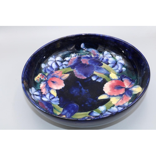 696 - Moorcroft Pottery, Orchid pattern fruit bowl, dark blue ground, D27.5cm