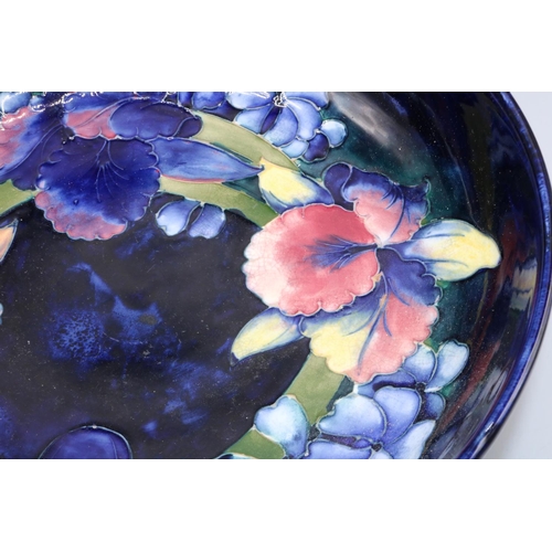 696 - Moorcroft Pottery, Orchid pattern fruit bowl, dark blue ground, D27.5cm