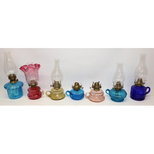 217 - Collection of finger oil lamps with coloured glass reservoirs, one with cranberry glass shade, max. ... 