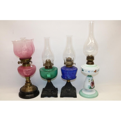 218 - Three oil lamps with coloured glass reservoirs incl. one with shade, and a painted opaline glass oil... 