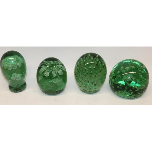 315 - Four Victorian green glass dumps, comprising two with sprays of air bubbles, and two with inset flor... 