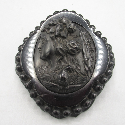 169 - Jet cameo brooch depicting a Greek woman in profile, surrounded by a beaded border, approx. 7cm x 7c... 