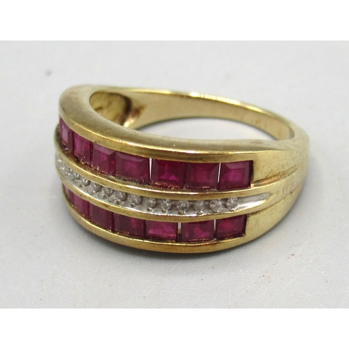 245 - 9ct yellow gold diamond and ruby ring, the central row of diamonds surrounded by square cut rubies, ... 