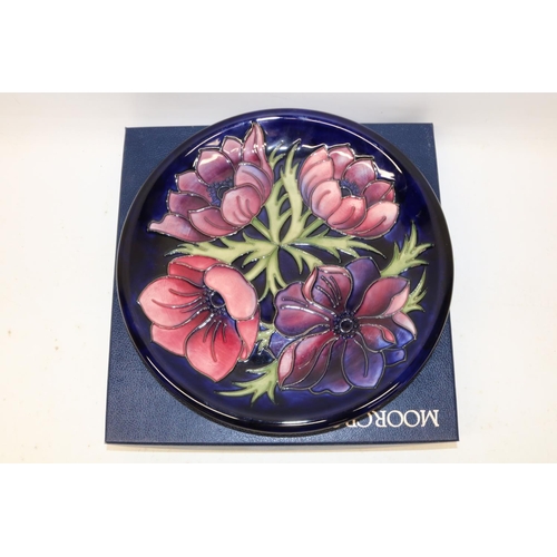 709 - Moorcroft Pottery, Anemone pattern plate, red and purple flowers on dark blue ground, D26cm, with bo... 