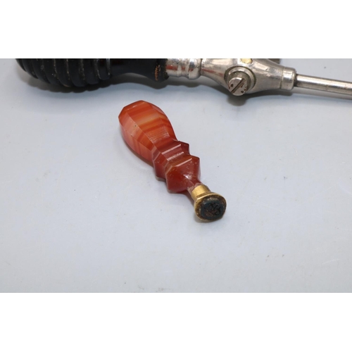 74 - Orange agate desk seal, L5cm, and an early 20th century champagne tap with ebonised handle (2)